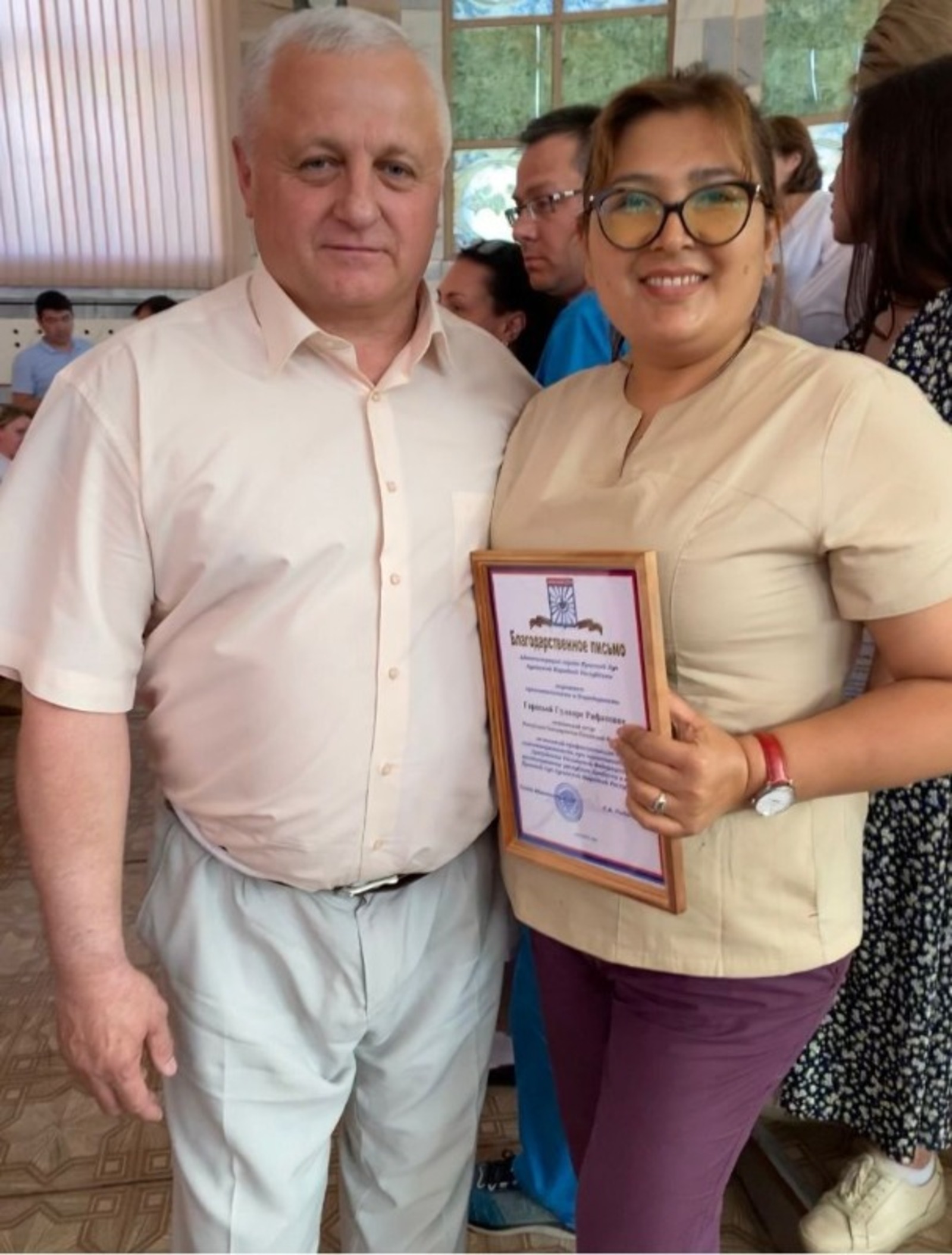 Гульнара Рифатовна получает награду из рук мэра Красного луча Сергея Анатольевича Рыбальченко