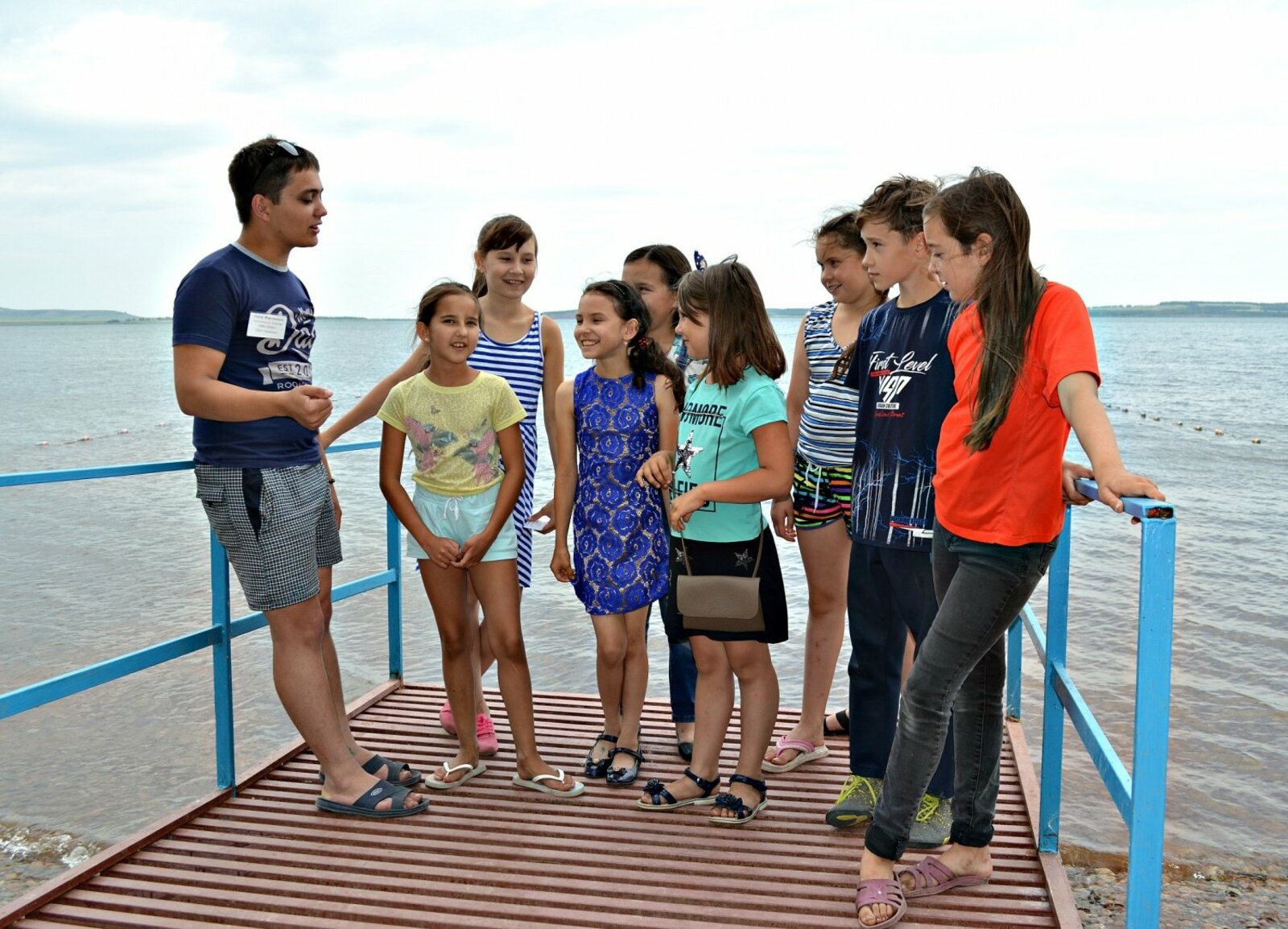 Воспитатель третьего отряда  Линар Максютов (крайний слева)  рассказывает ребятам об озере.