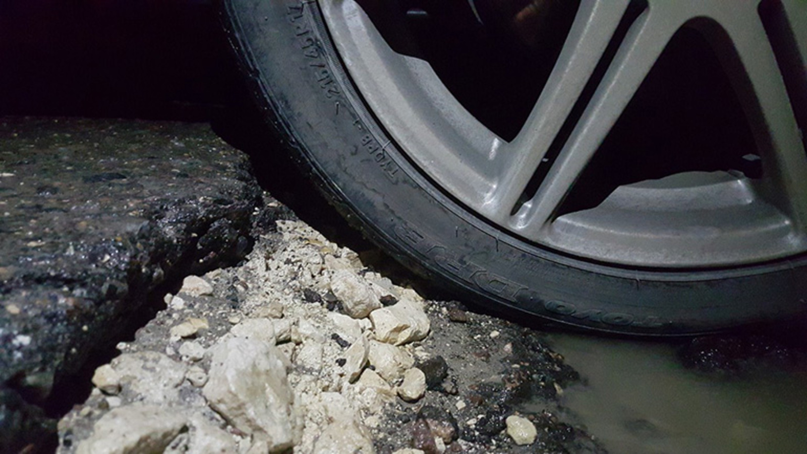 Колесо попало в яму на дороге. Колесо в яме на дороге. Пробил колесо на дороге. Попадание колеса в яму.